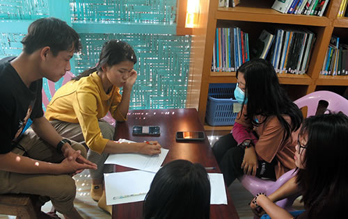 Studends around a desk in school in Myanmar